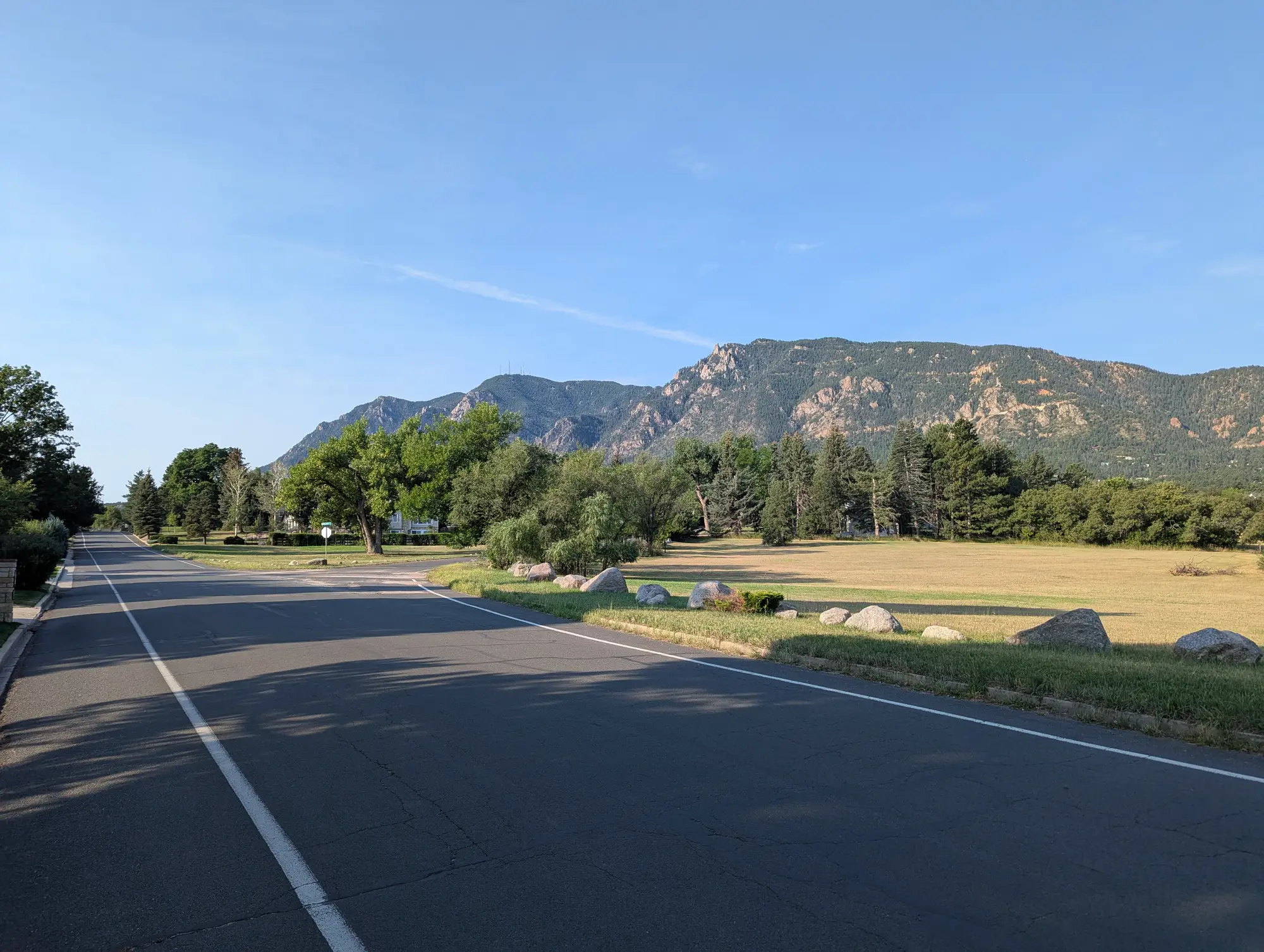 Cheyenne Mountain rising above a quiet road in Colorado Springs